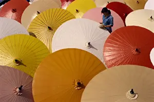 Chiang Mai Prints: Woman finishing painted umbrellas in a village near Chiang Mai
