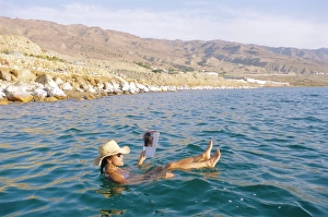 Straw Hat Prints: Woman floating in the Dead Sea reading a magazine