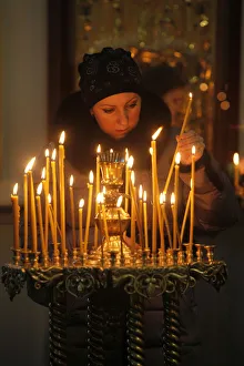 25 30 Years Prints: Woman lighting a candle, Trinity Cathedral, St. Petersburg, Russia, Europe
