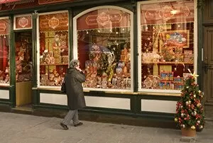 Woman looking at chocolate shop selling Mozart chocolates and other Christmas sweets