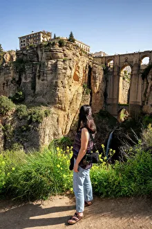 Mid Adults Prints: Woman looking at historic bridge of Ronda, Pueblos Blancos, Andalusia, Spain, Europe