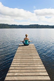 Yoga Prints: Woman meditating on a jetty, Lake Ianthe, West Coast, South Island, New Zealand, Pacific