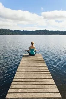 Images Dated 12th April 2011: Woman meditating on a jetty, Lake Ianthe, West Coast, South Island, New Zealand, Pacific
