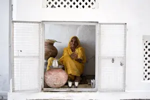 Udaipur Prints: Woman offering drinking water to devotees at Jagdish temple, Udaipur, Rajasthan