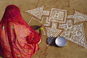 Mandala Prints: Woman painting a Mandala design on the ground