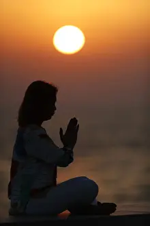 40 To 45 Prints: Woman practising yoga pose and meditation at sunset as concept for silence and relaxation