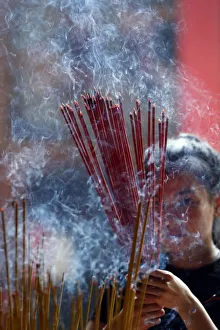 Females Prints: Woman praying with burning incense sticks, Ong Bon Pagoda, Taoist Temple