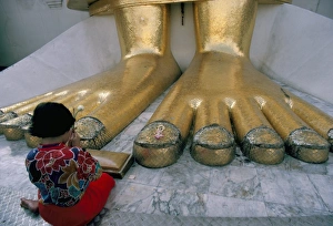 Thai Culture Prints: Woman praying at the feet of the Buddha in the temple