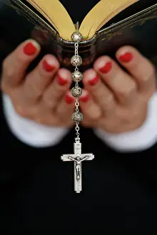 Human Hand Prints: Woman reading the Bible, close up on vintage rosary with crucifix