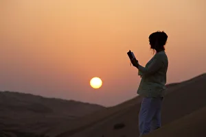 Images Dated 28th October 2009: Woman reading the Bible in the desert, Abu Dhabi, United Arab Emirates, Middle East