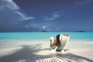 Woman reading a book on the beach, Maldives, Indian Ocean, Asia