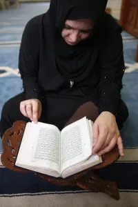 Books Prints: Woman reading Koran in Jumeirah mosque, Dubai, United Arab Emirates, Middle East