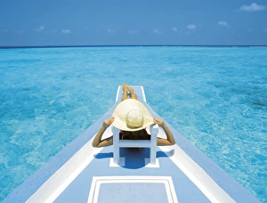 Enjoying Prints: Woman relaxing on deck of boat, Maldives, Indian Ocean, Asia