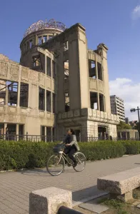 Warfare Prints: Woman riding bicycle past A Bomb Dome