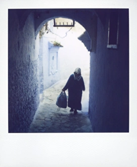 Chefchaouen Prints: Woman in semi-silhouette walking through archway