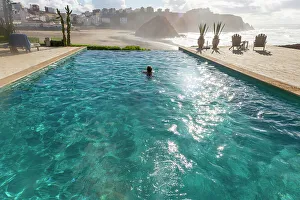Infinity Pool Prints: Woman swimming in infinity pool by Atlantic Ocean