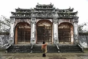 Woman taking photo of temple gates, Vietnam, Indochina, Southeast Asia, Asia