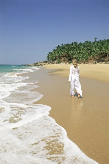 Kovalam Prints: Woman tourist walking along the beach