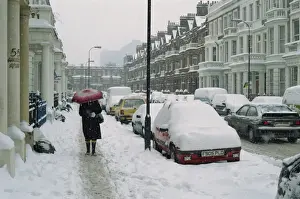 Kensington Prints: Woman with umbrella and cars covered in snow in winter in West Kensington