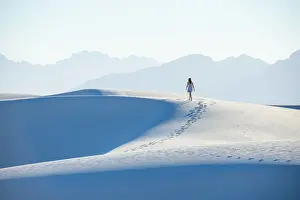 35 To 39 Years Prints: A woman walking along a dunes ridge in White Sands National Park, New Mexico