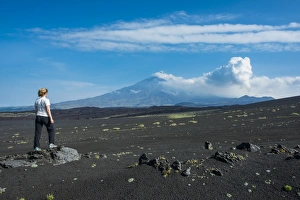Black Sand Prints: Woman watching Tolbachik volcano, Kamchatka, Russia, Eurasia