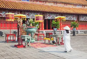 South East Asian Prints: Woman wearing Ao Dai dress at Mieu Temple inside Citadel