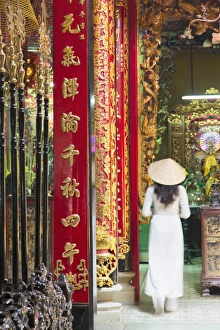 Woman wearing ao dai dress at Phuoc An Hoi Quan Pagoda, Cholon, Ho Chi Minh City