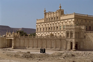 Women in black passing the house of a trader made rich