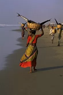 Women carrying fish catch to the market of fishing village
