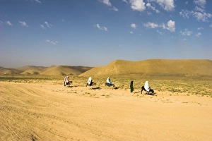Women ride donkeys along side of road between Maimana and Mazar-I-Sharif