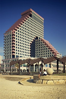 Two women talking on the beach, with the Opera Tower in the background