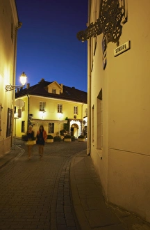Vilnius Prints: Two women walking along Stikliu Gatve at dusk, Vilnius, Lithuania, Baltic States, Europe