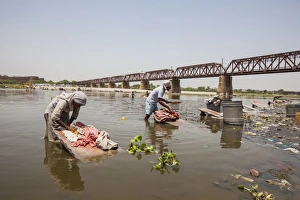 Images Dated 30th April 2010: Women wash clothes in the polluted water of the Yamuna River, a tributary of the Ganges