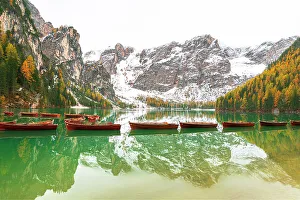 Reflective Prints: Wooden boats floating on calm waters of Braies lake
