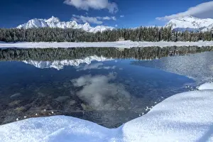 Lake Palu Prints: Wooden chalet surrounded by snowy peaks and woods reflected in Lake Palu, Malenco Valley