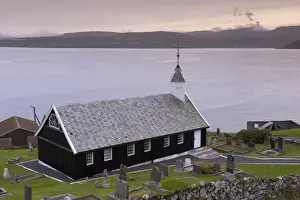 Tomb Stones Prints: Wooden church at Nes dating from 1843, view across Tangafjordur towards Streymoy