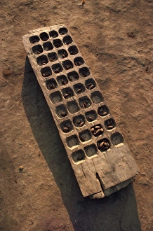 Sudan Prints: Wooden gaming board (houri) and dried beads, Maridi village, Sudan, Africa