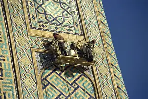Repairing Prints: Workers in cradle refurbishing the 17th century Sher Dor Madressa, Registan Square