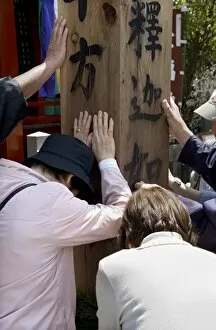 Images Dated 1st May 2009: Worshippers touching a wooden obelisk for inspiration at a sub temple of Zenkoji Temple