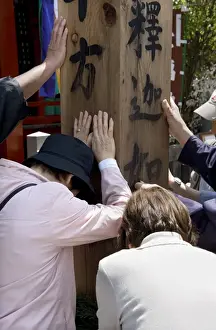 Touching Prints: Worshippers touching a wooden obelisk for inspiration at a sub temple of Zenkoji Temple