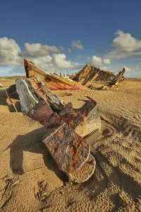 Crow Prints: Wreck of a boat on sand at Crow Point near Barnstaple in Devon on a sunny day with clouds