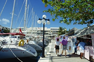 Leeward Island Prints: Yachts in the marina and small stalls selling to tourists