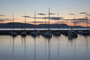 Lyme Regis Prints: Yachts moored in The Cobb with Jurassic Coast and Golden Cap at sunrise, Lyme Regis