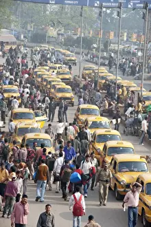 Crowded Prints: Yellow Kolkata taxis and commuters outside Howrah Railway Station in morning rush hour
