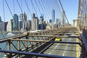 East River Prints: Yellow taxi cab crossing Brooklyn Bridge with the Lower Manhattan skyline behind