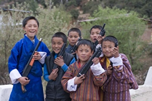 Paro Prints: Young Bhutanese boys playing with their toy guns, Paro, Bhutan, Asia