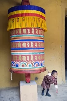 Images Dated 3rd October 2009: Young boy pulling a prayer wheel, Jakar Dzong, Castle of the White Bird