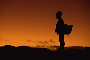 One Boy Only Prints: Young boy silhouetted against sky at dusk, Tibet, China, Asia