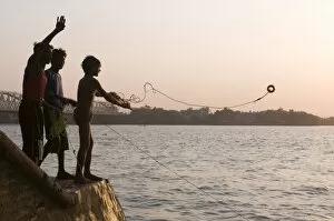 Young boys fishing for metal coins in the Howrah River, Kolkata (Calcutta)