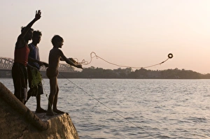 Images Dated 13th April 2009: Young boys fishing for metal coins in the Howrah River, Kolkata (Calcutta)